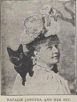 Czarno biały portret z XIX wieku podpisany “Natalie Janotha and her pet”. Kobieta ma na głwie fikuśny kapelusz, jest odwrócona do widza pół profilem i patrzy w dal. Na jej ramieniu siedzi czarny kot